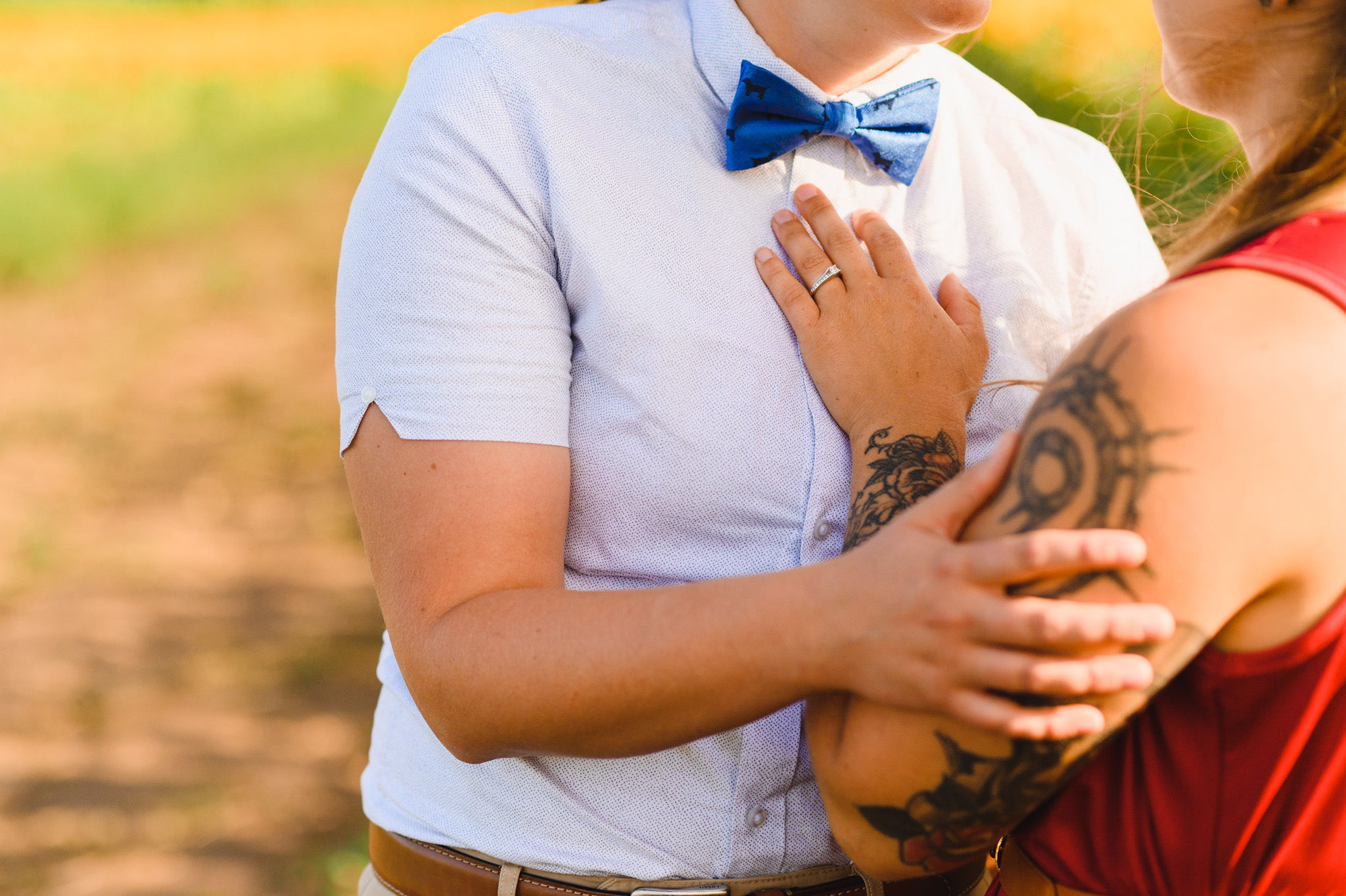 woman placing her hand on her partners chest during their stunning sunflower field engagement shoot