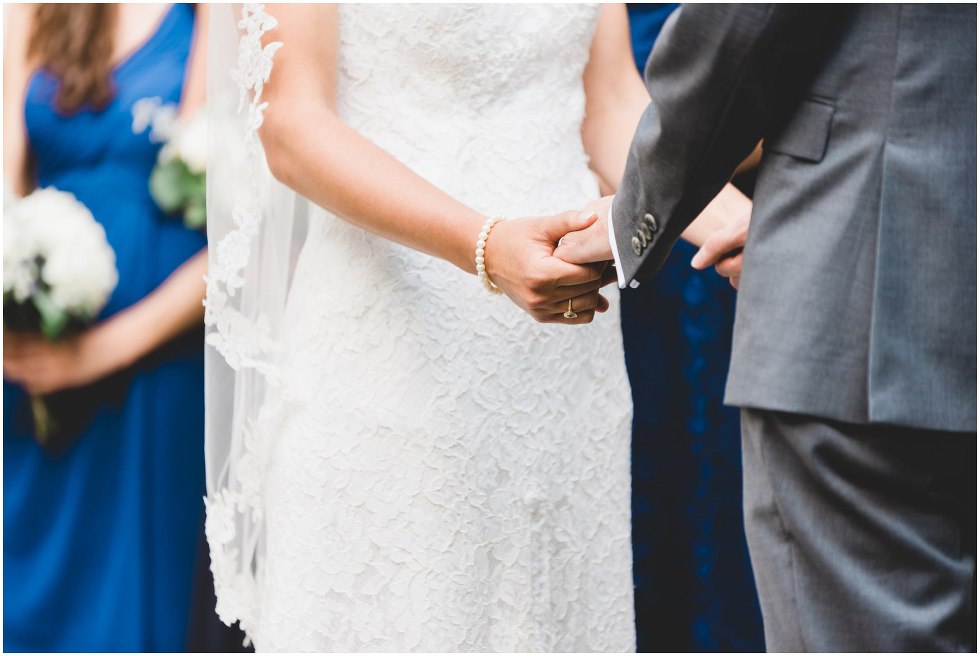 Bride and groom holding hands during the Goldie Mill Ruins wedding ceremony