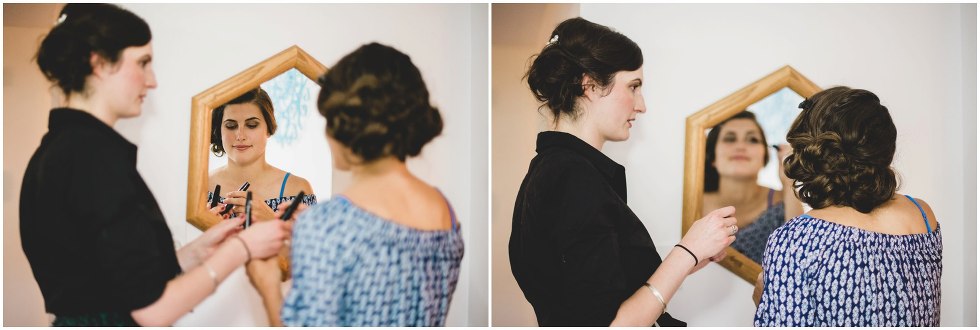 Bride putting on eye makeup as she looks in the mirror 