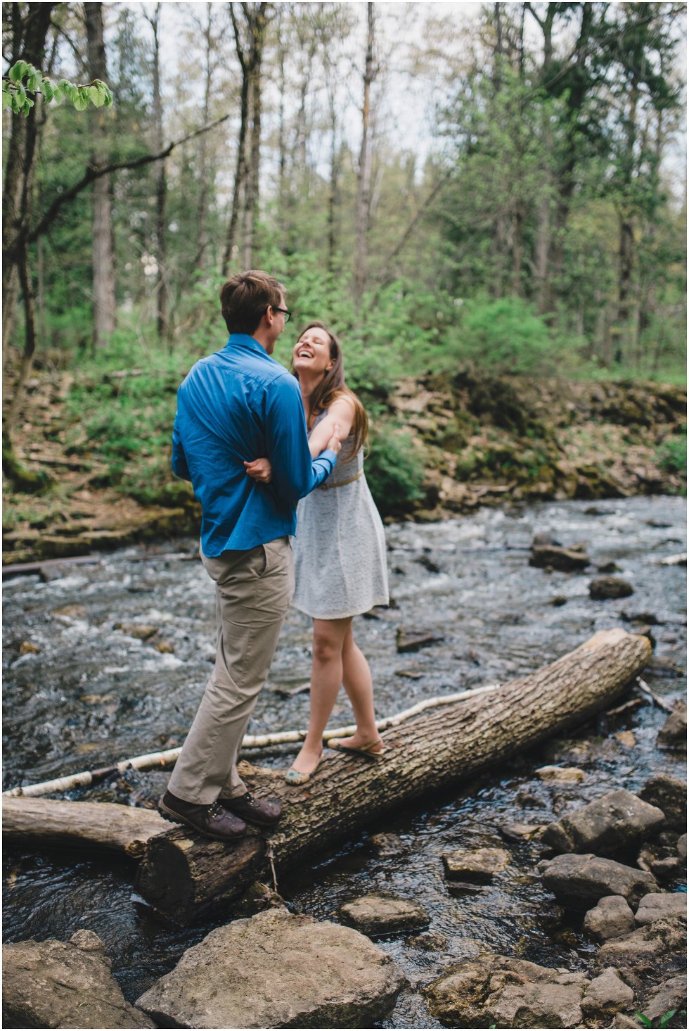 Engaged couple laughing and smiling on a log
