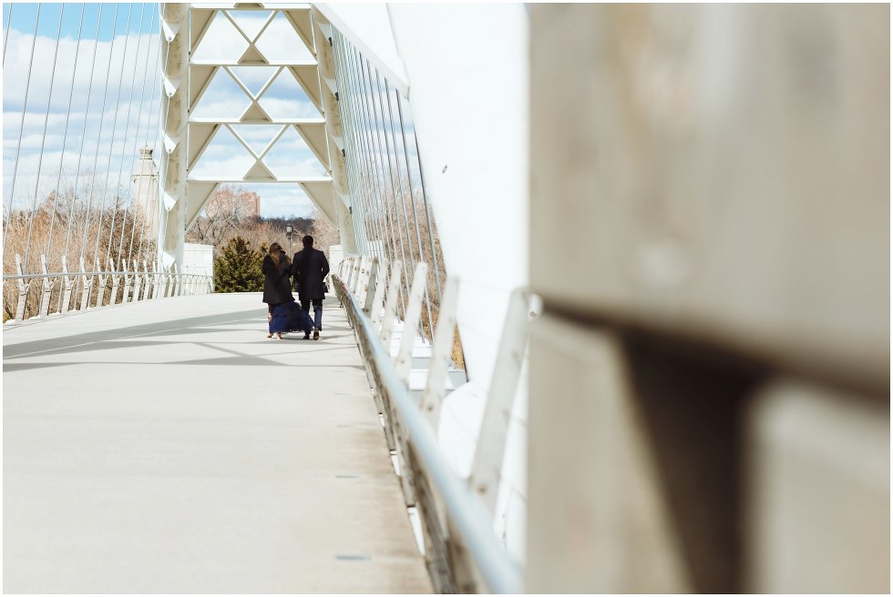 couple walking across white bridge Toronto engagement photographer