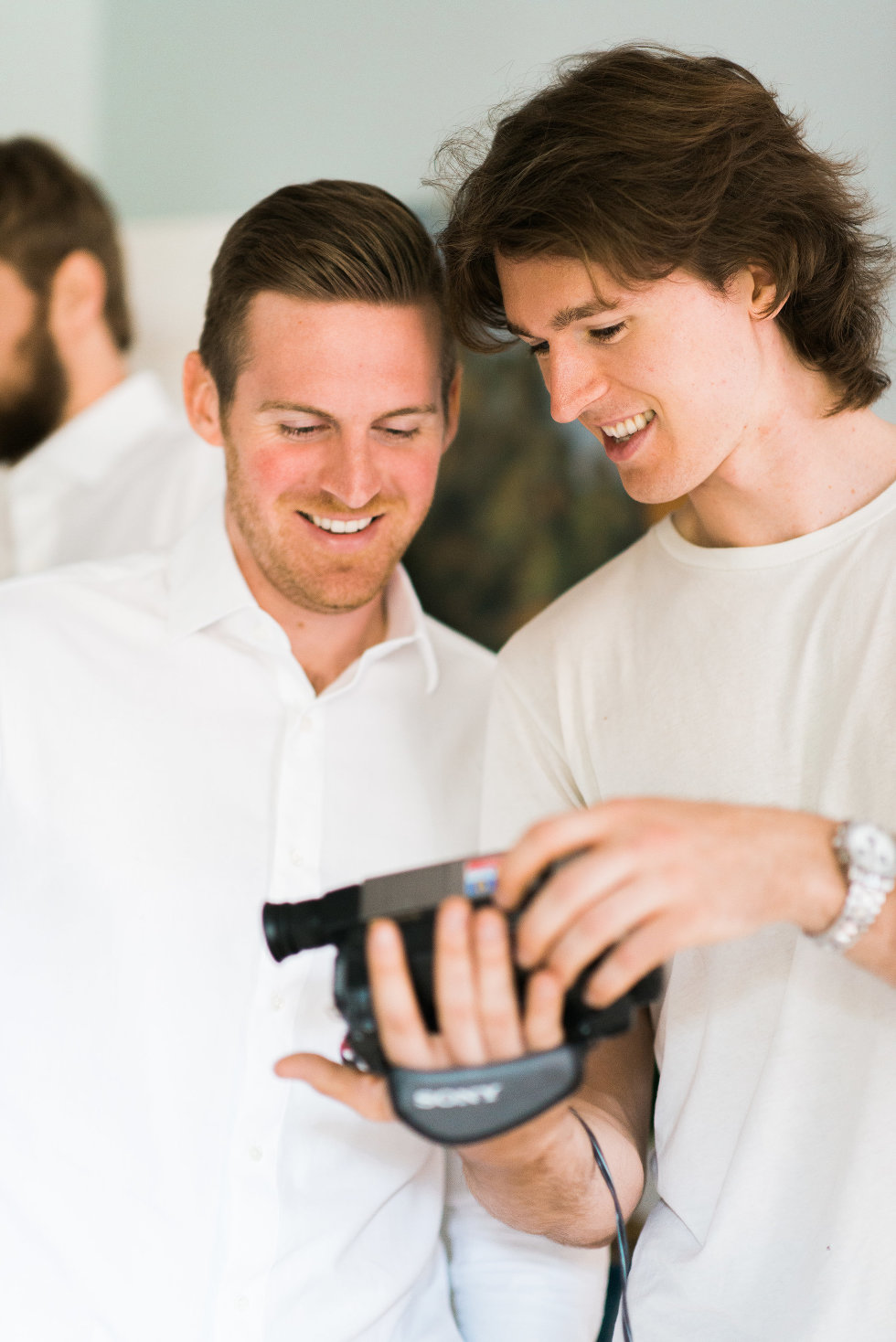 groom showing groomsman video recorder Toronto wedding photographer