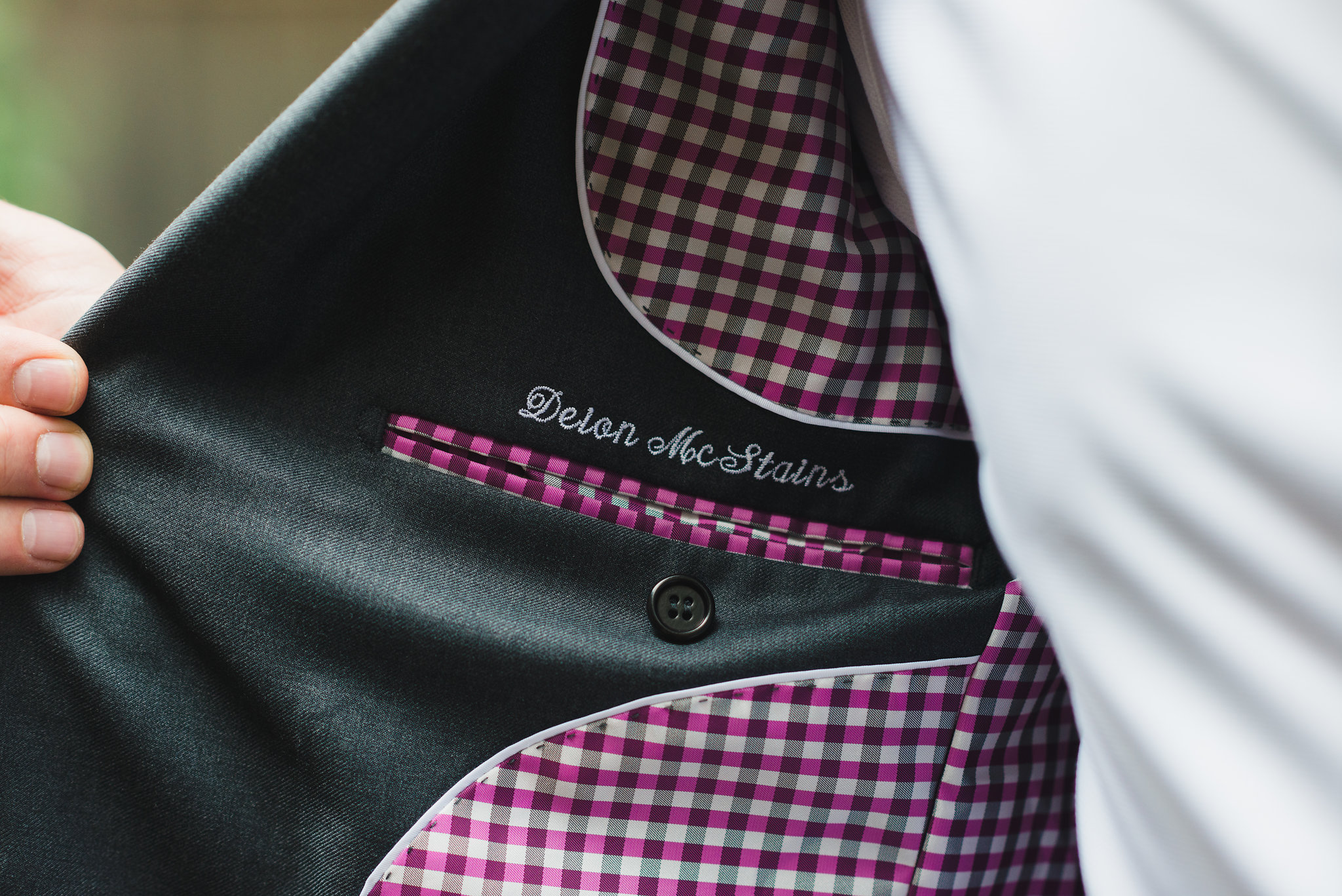 man holding open suit jacket to reveal embroidery Toronto wedding photographer