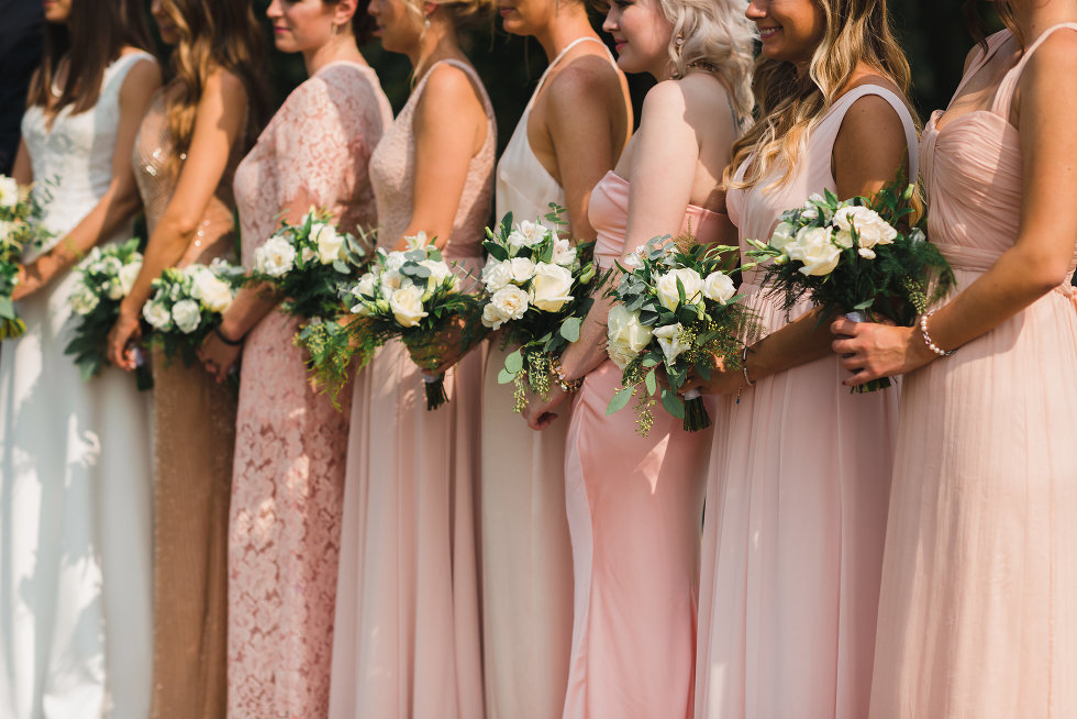 bride and her bridesmaids in a line holding bouquets Toronto wedding photography