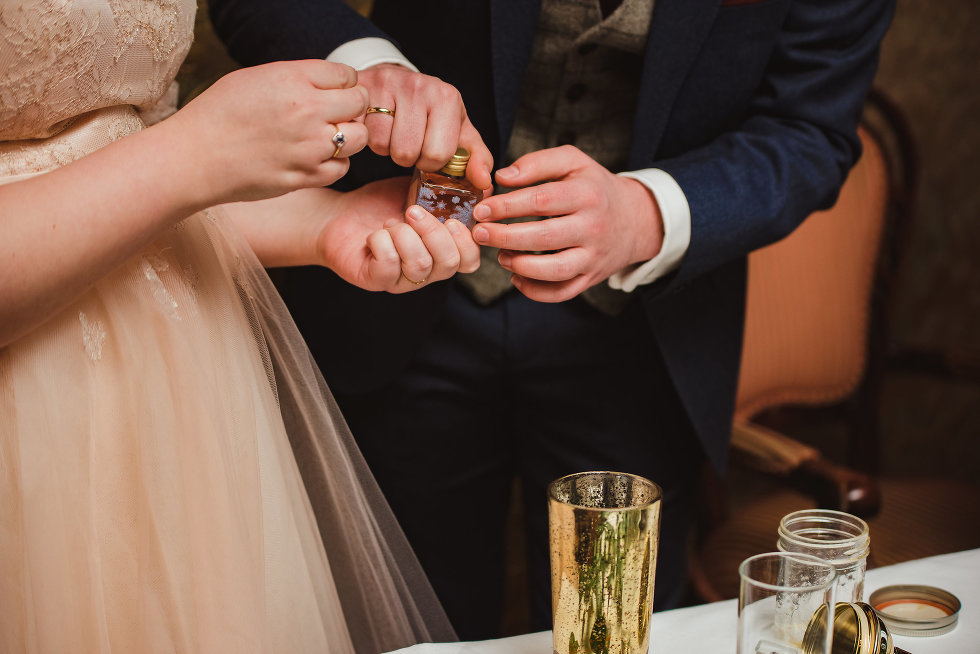 bride and groom unscrewing cap to bottle of gin Niagara wedding photography