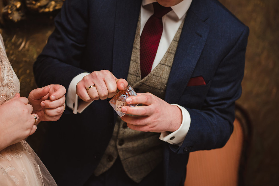 groom unscrewing cap to bottle of gin Niagara wedding photography