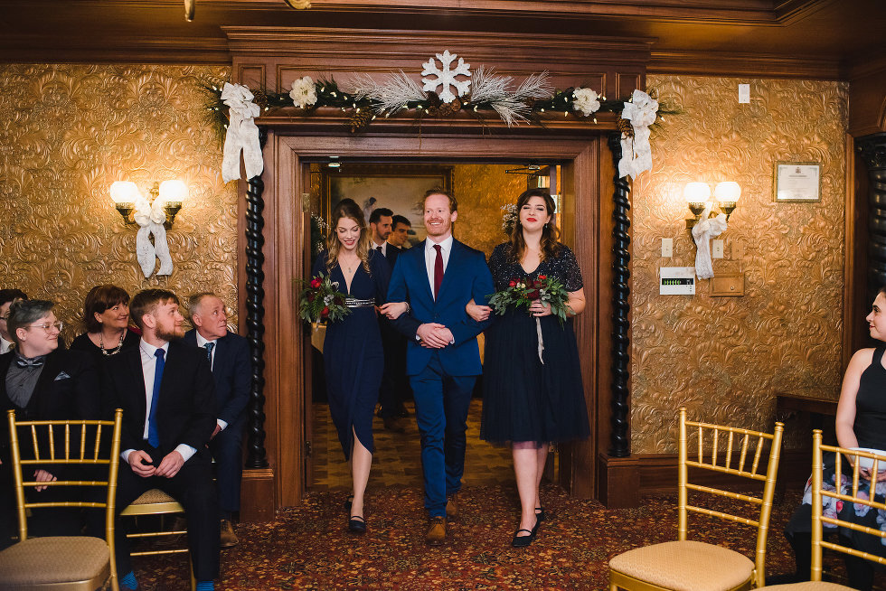 wedding guests watch as a groomsman and two bridesmaids enter Victorian room Prince of Wales Hotel Niagara wedding