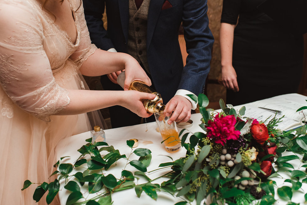 bride and groom pour cocktail from shaker into glass Niagara wedding photography Gillian Foster