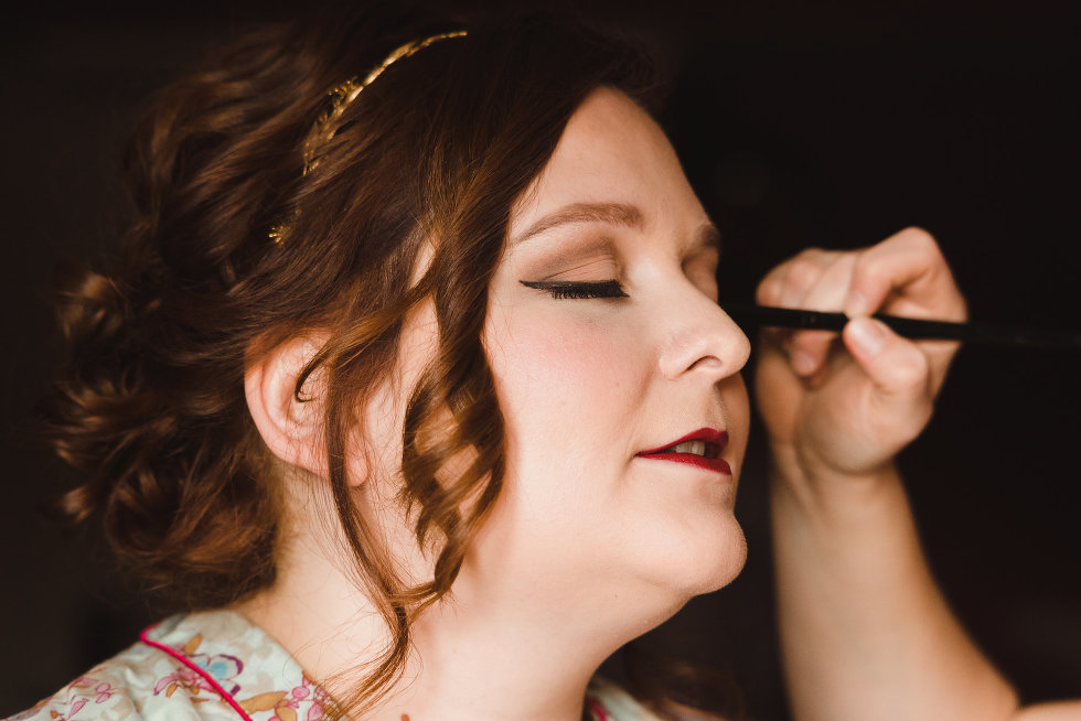 bride with eyes closed as her makeup artist applies eyeliner Toronto wedding
