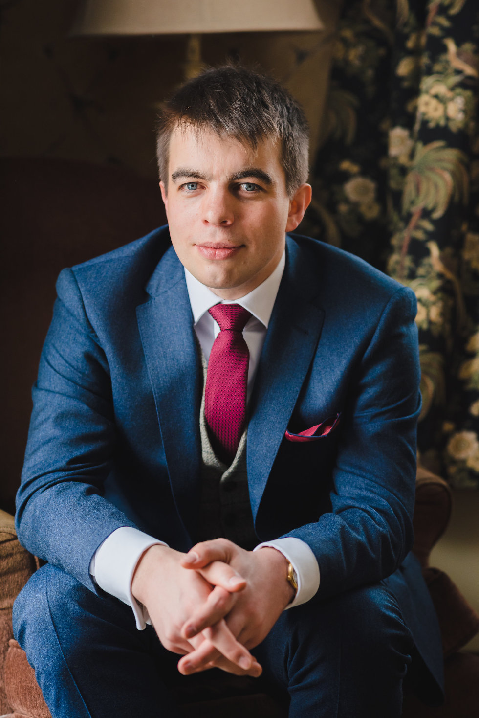 groom in blue suit with burgundy necktie sitting down Niagara wedding photographer