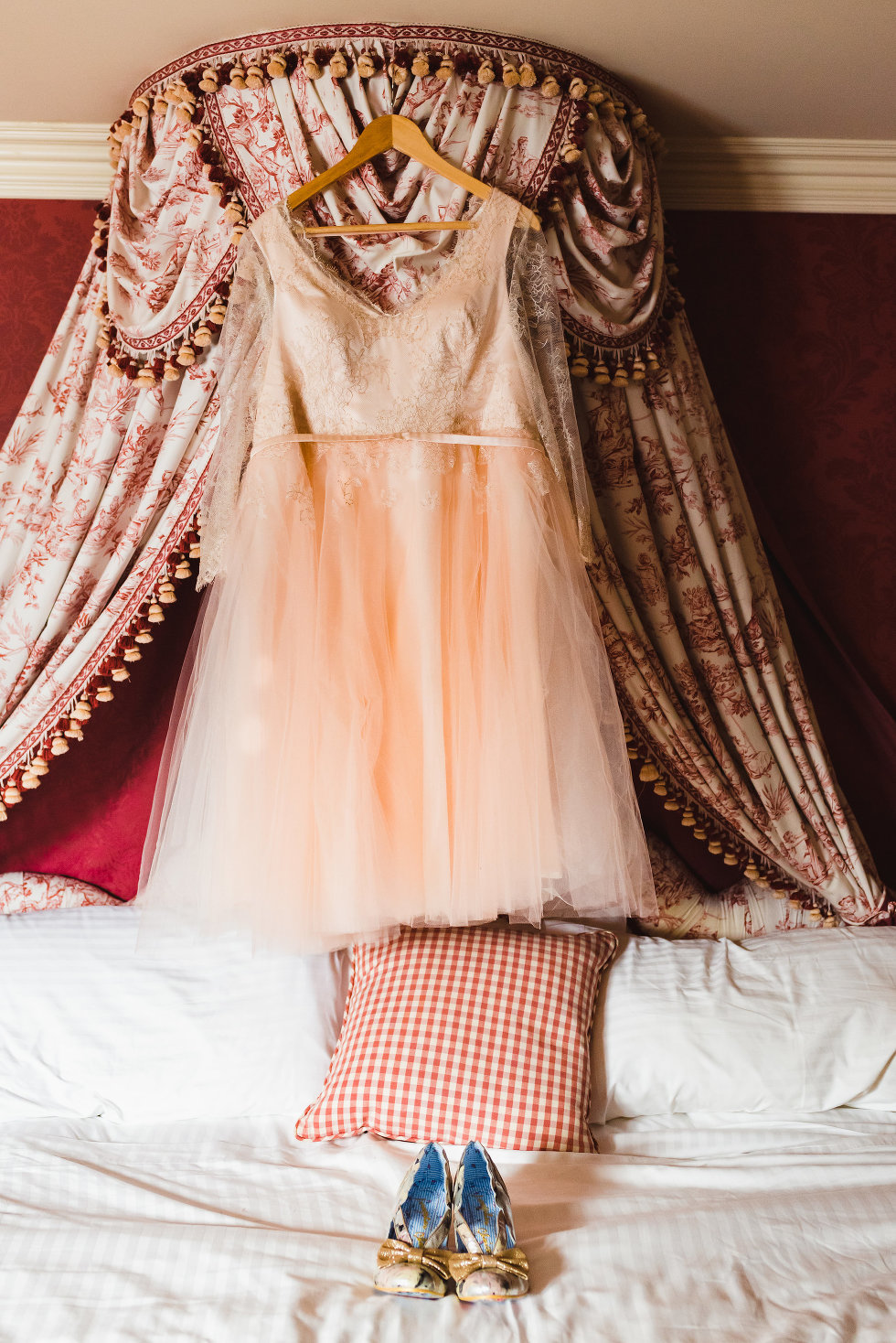 wedding dress hanging on headboard above white bed and wedding shoes Toronto Wedding photographer