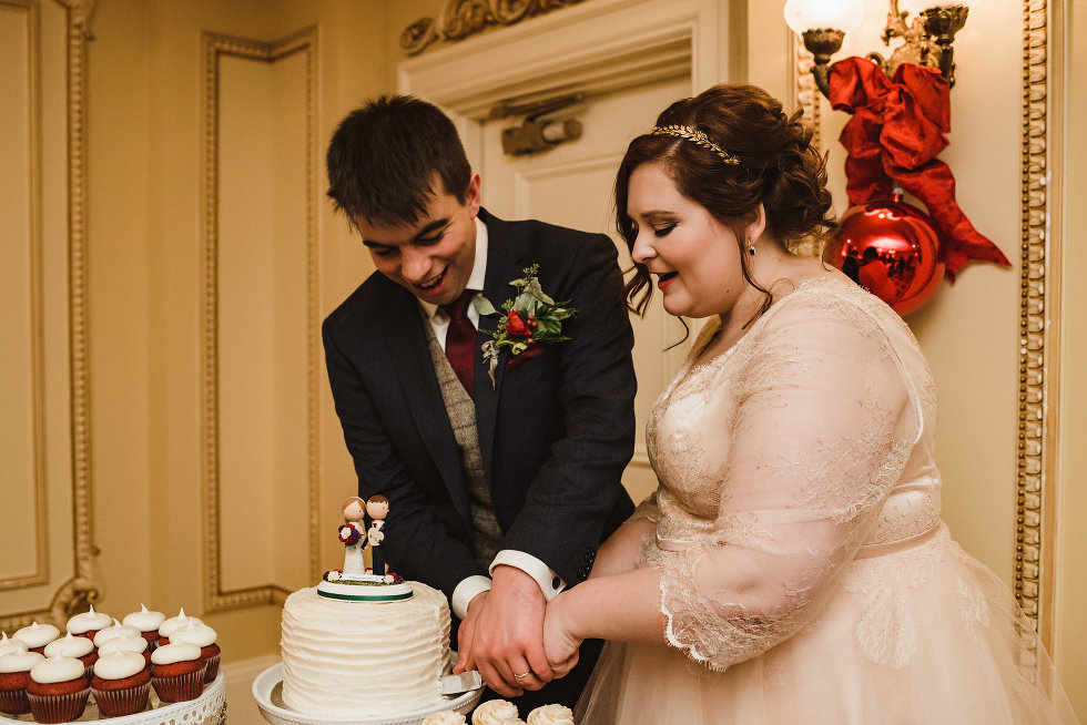 bride and groom cut into wedding cake Niagara wedding photography