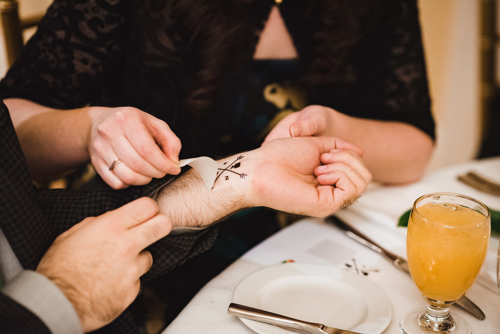 wedding guests apply temporary tattoos at reception table in Prince of Wales Hotel Niagara wedding photography