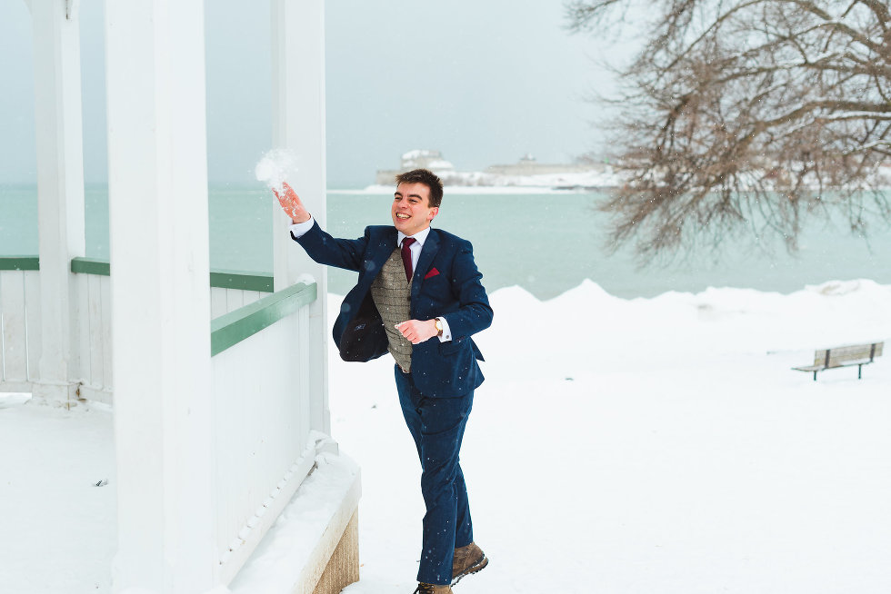 groom throwing snowball throw white gazebo Niagara wedding photography