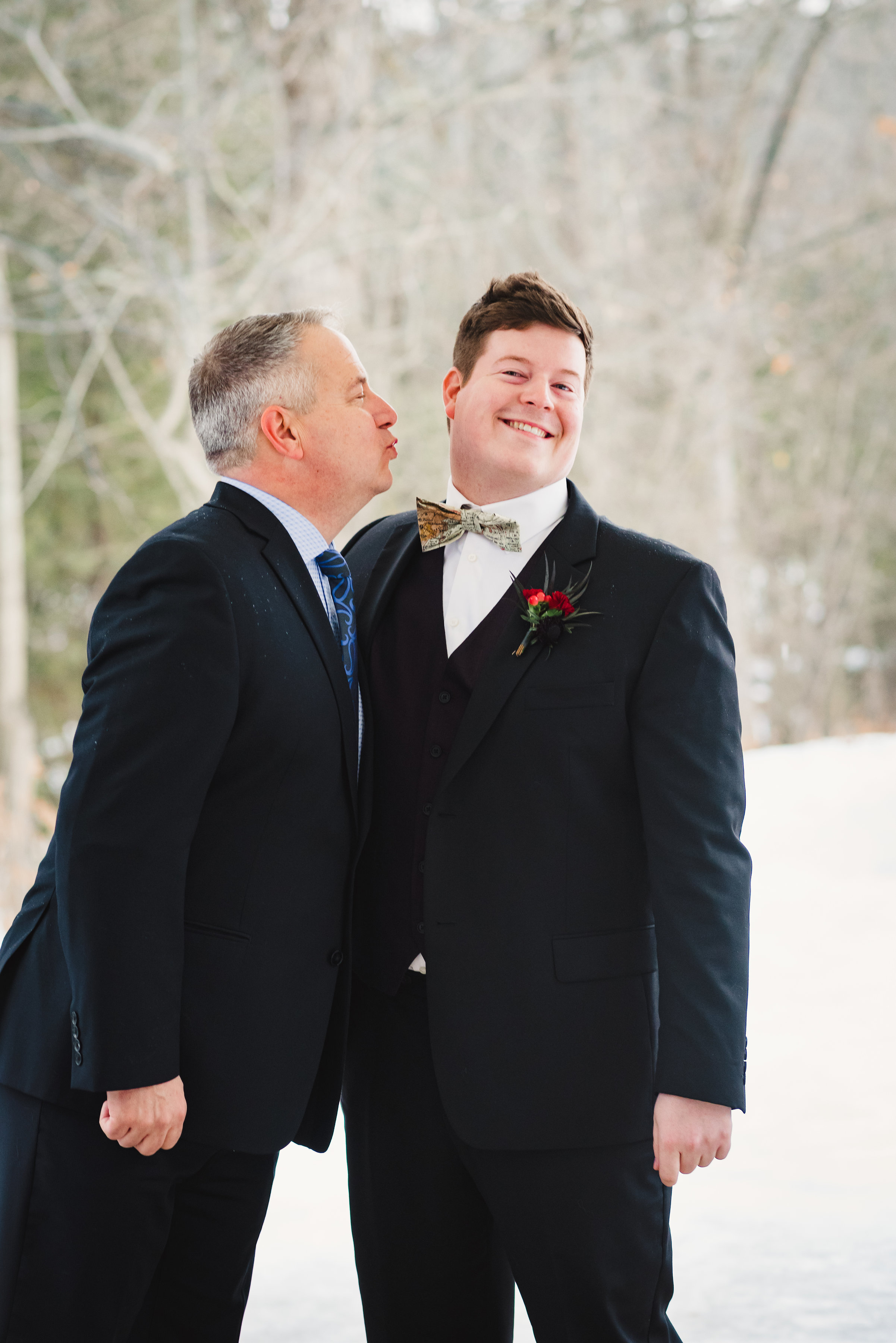 father of the groom attempting to kiss the groom on the check Canadian Canoe Museum wedding