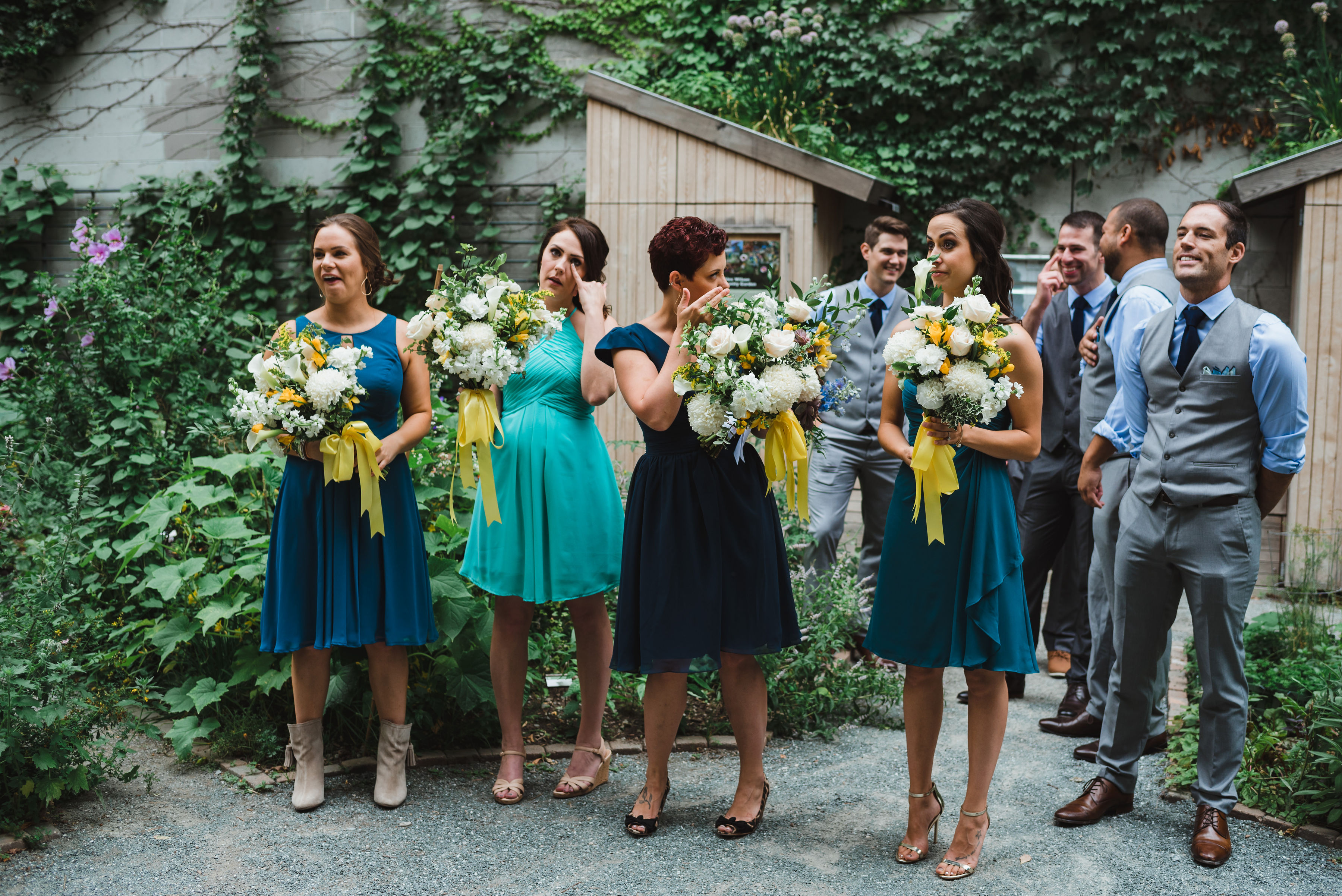 wedding party in a garden reacting with tears as bride and groom share their first look in front of them Toronto Junction Craft Brewing wedding photography
