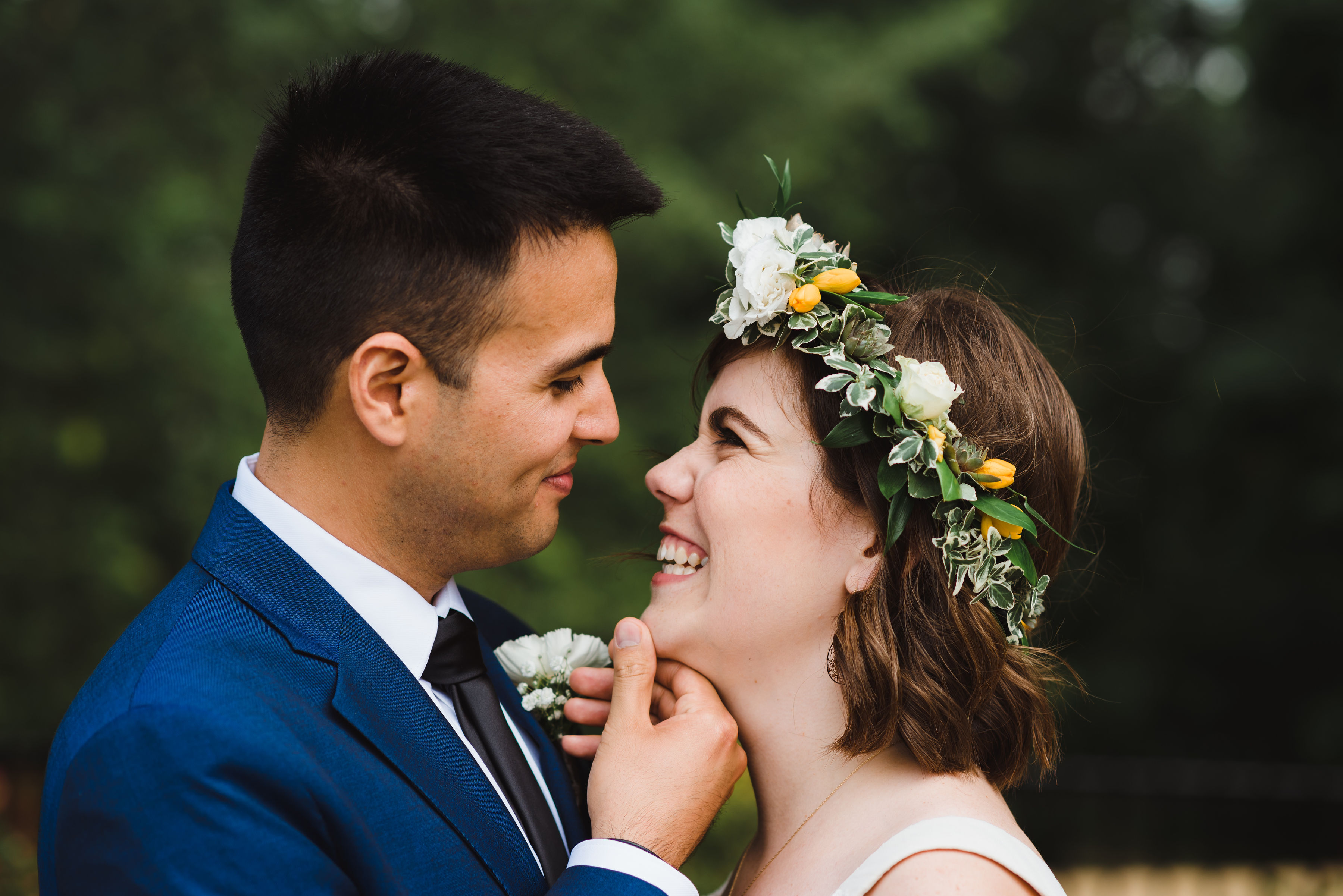 groom places his hand on his brides chin as she smile back at him Toronto brewery wedding photography Gillian Foster