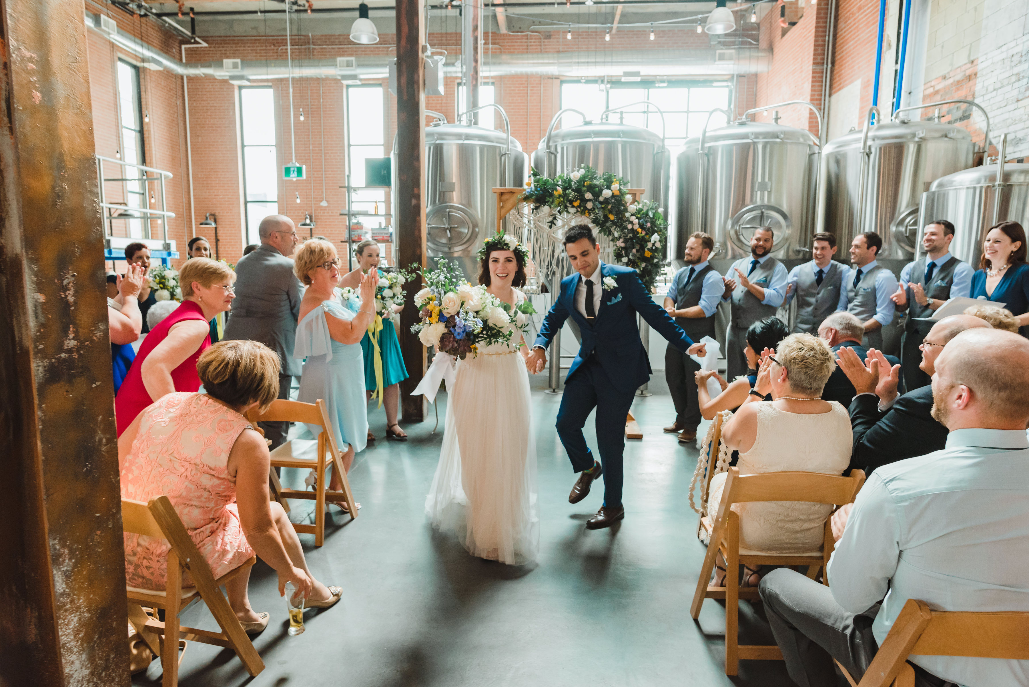 bride and groom dancing their way down the aisle as they exit the ceremony Toronto Junction Craft Brewing 