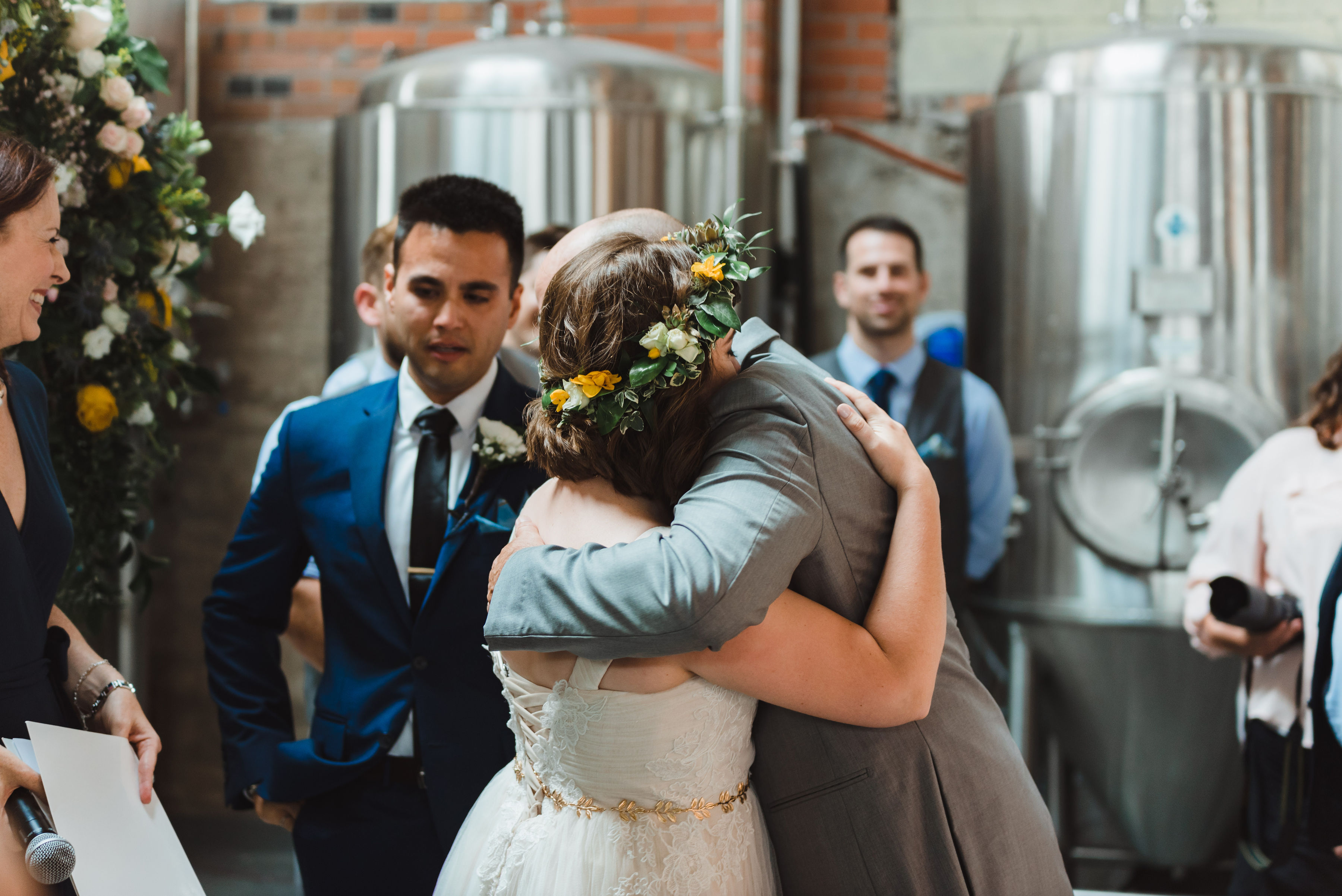 bride hugging her father after he walked her down the aisle Toronto Junction Craft Brewing wedding photography
