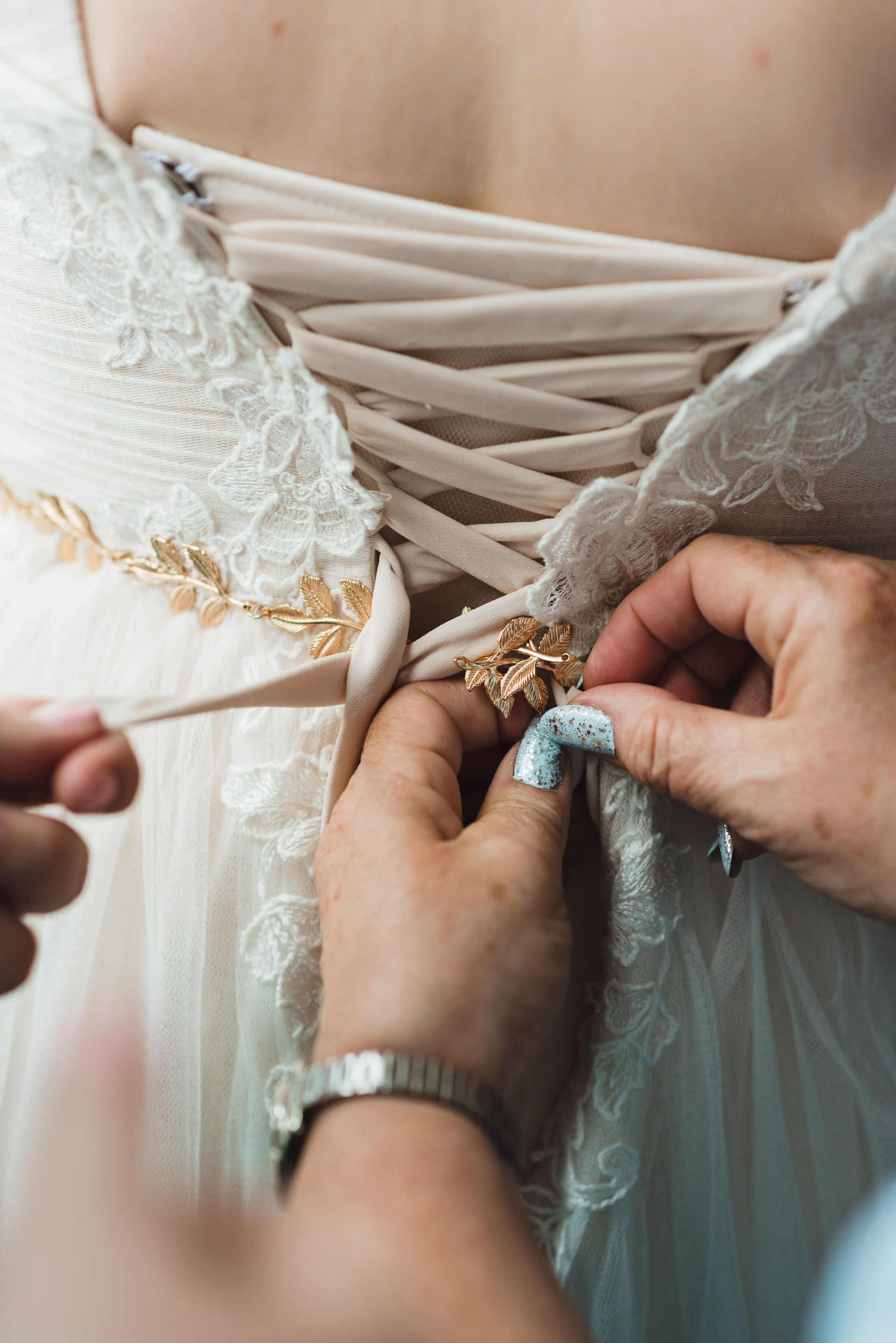 bride having her gown tied up in the back Toronto Junction Craft Brewing wedding photography