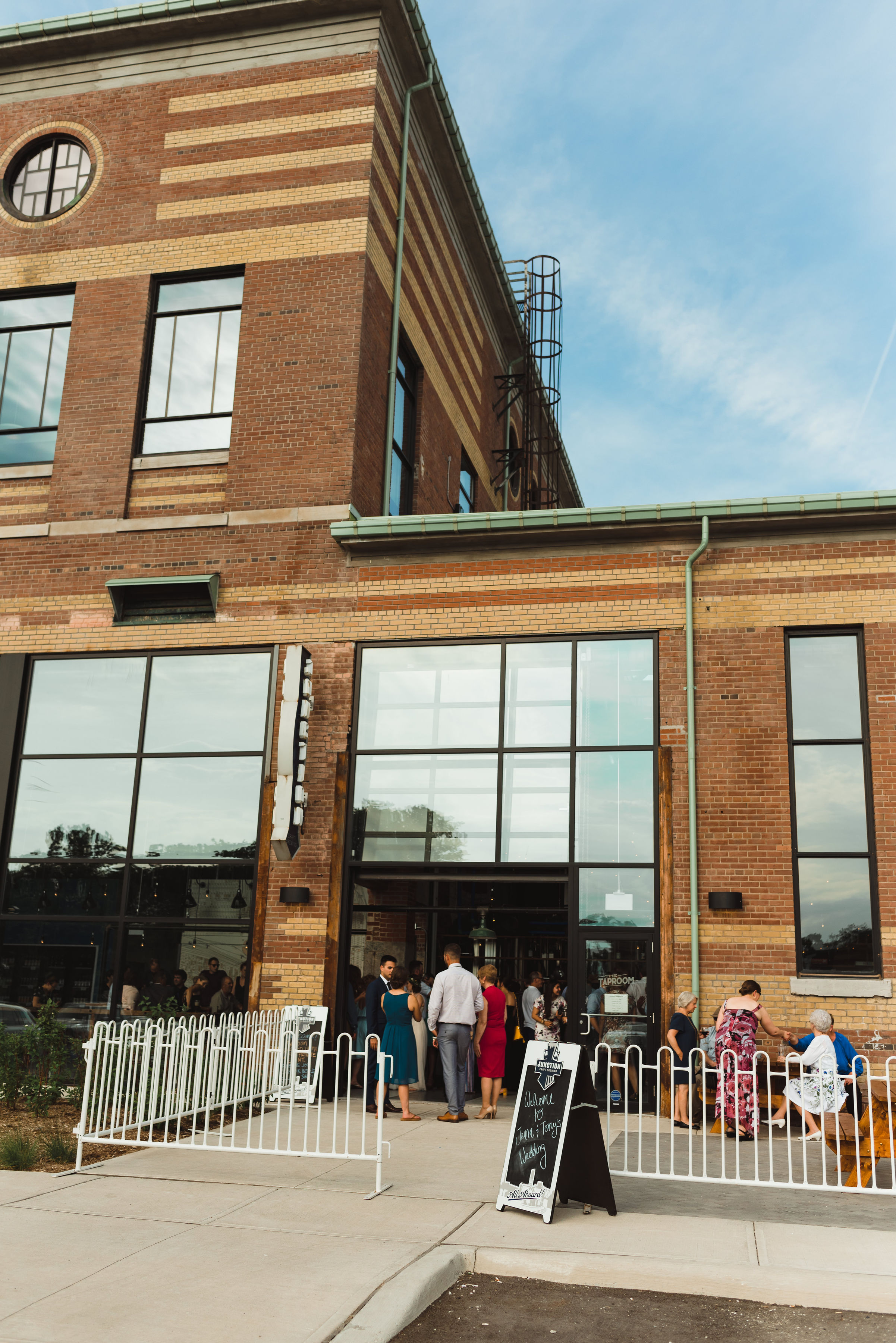 Junction Craft Brewing building with people mingling on their patio outside Toronto wedding photography