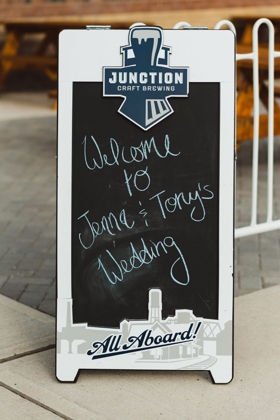 A frame chalk sign at Toronto brewery wedding that has "welcome to Jenna & Tony