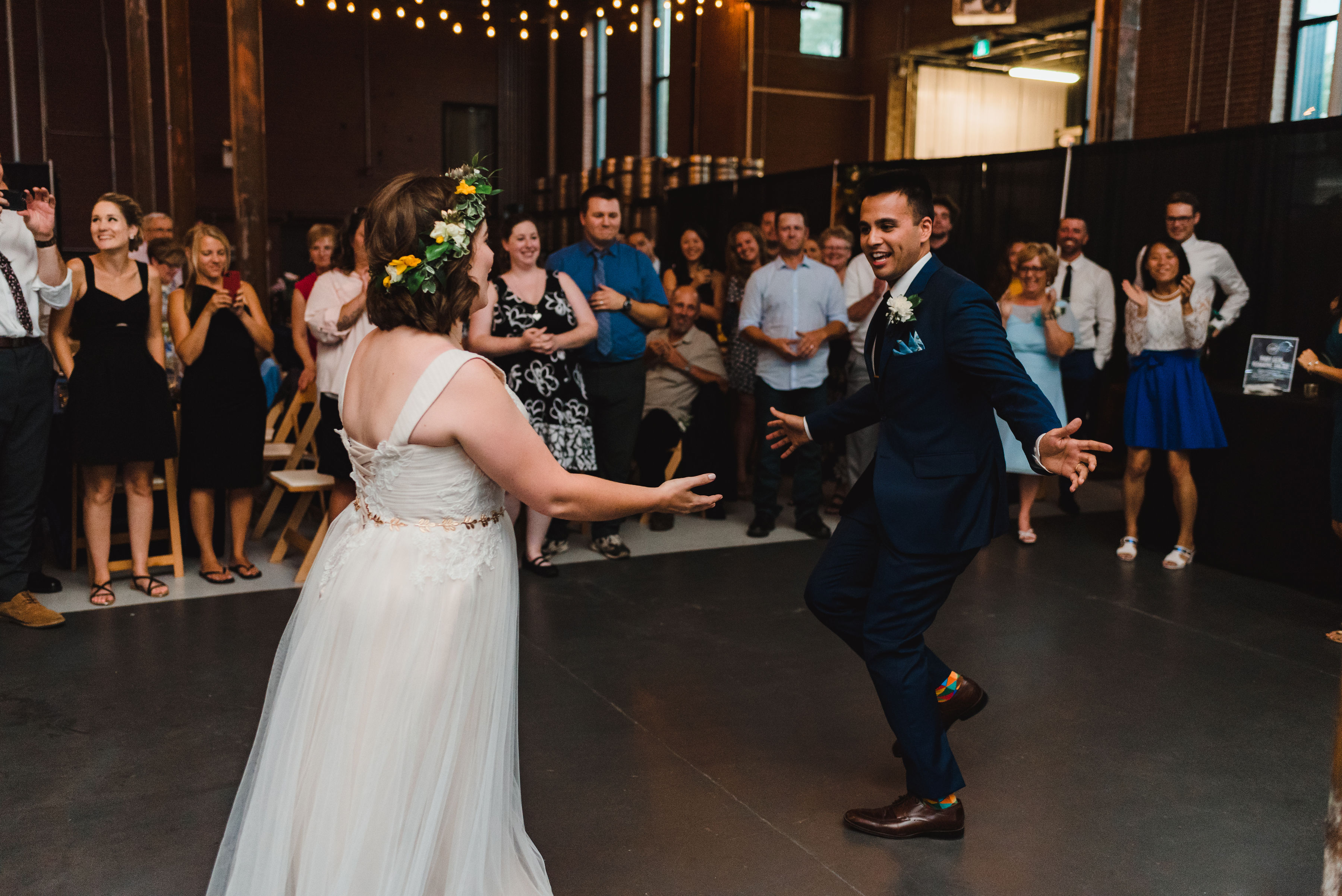 wedding guests watch as bride and groom share a first dance Junction Craft Brewing wedding photography