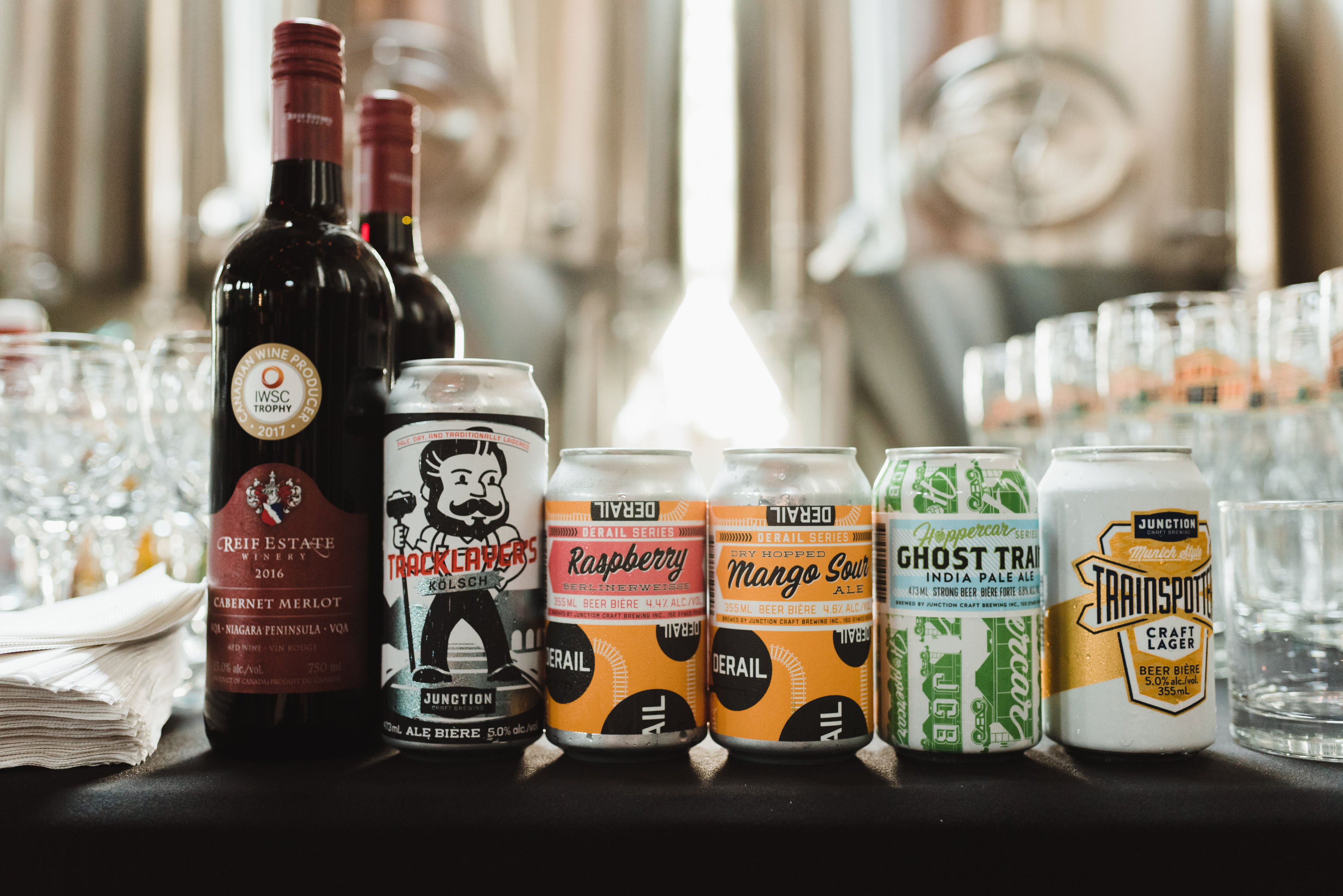 bar at a wedding with two bottles of red wine, glasses, and an assortment of cans of craft beer Toronto Junction Craft Brewing wedding