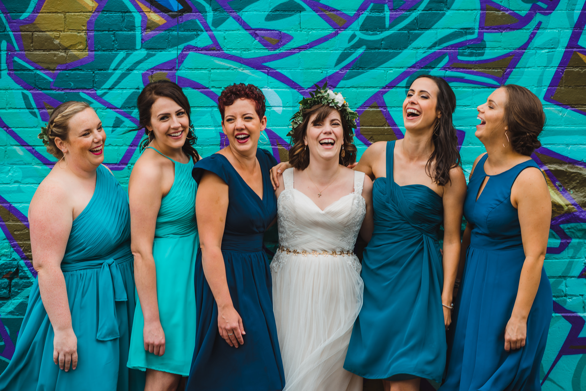 Bridal party in teal dresses laughing in Graffiti alley Toronto