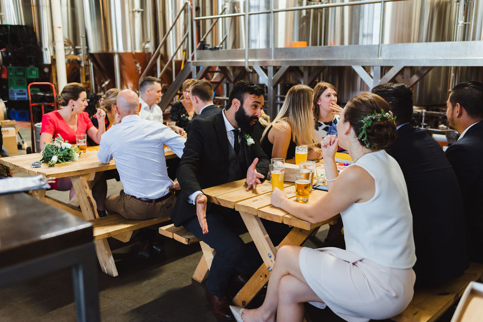 wedding guests sitting at picnic tables playing games and drinking pints of beer at Henderson