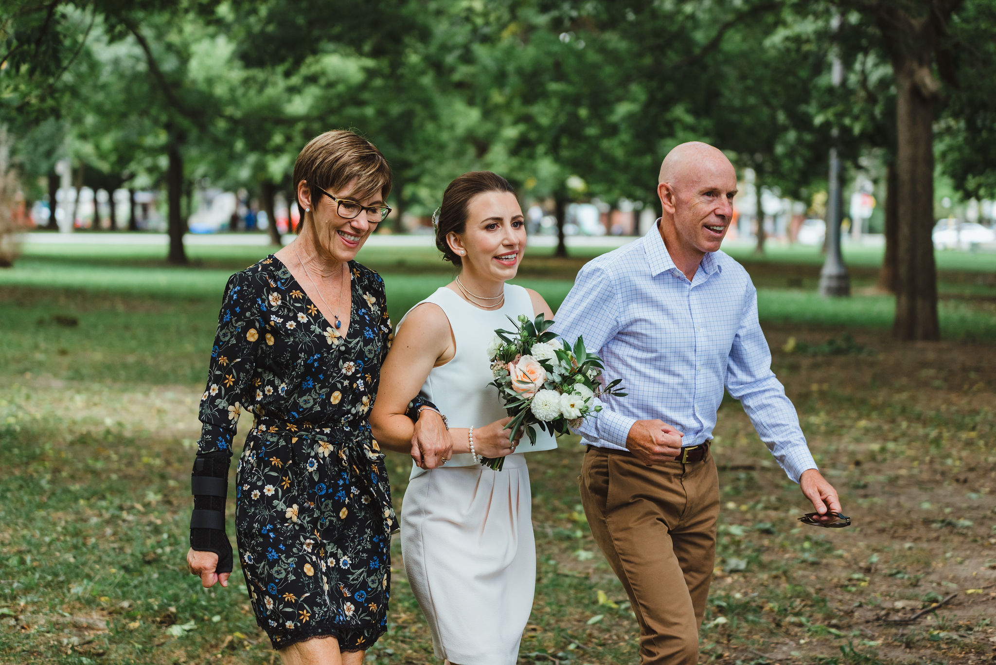 bride's parents escorting her down the aisle to the ceremony in Trinity Bellwoods Park Toronto Canada