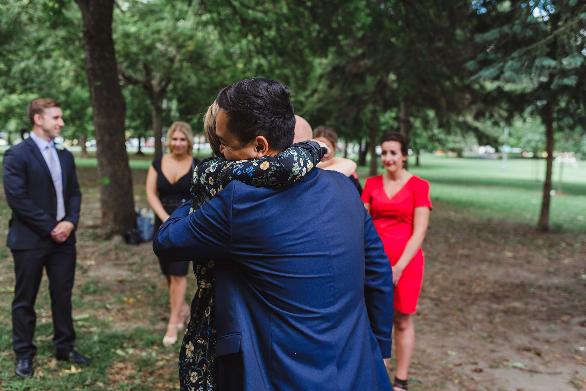 bride's mother hugging groom before ceremony in Trinity Bellwoods Park Toronto Canada