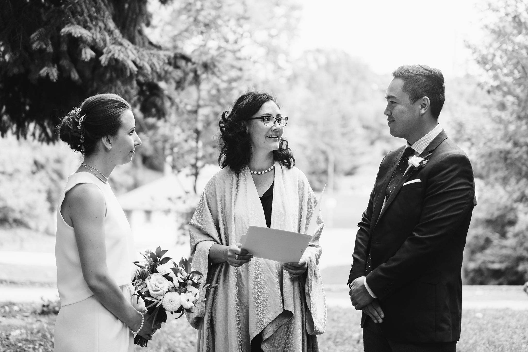 bride and groom stand before officiant as wedding ceremony begins Trinity Bellwoods wedding Toronto