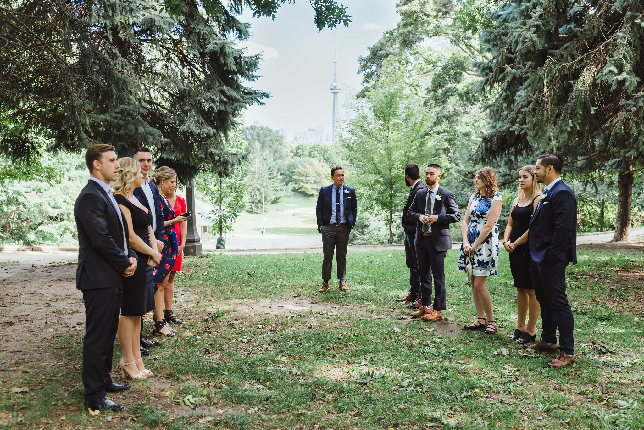 small wedding ceremony in Trinity Bellwood Park with view of CN tower behind them Toronto wedding