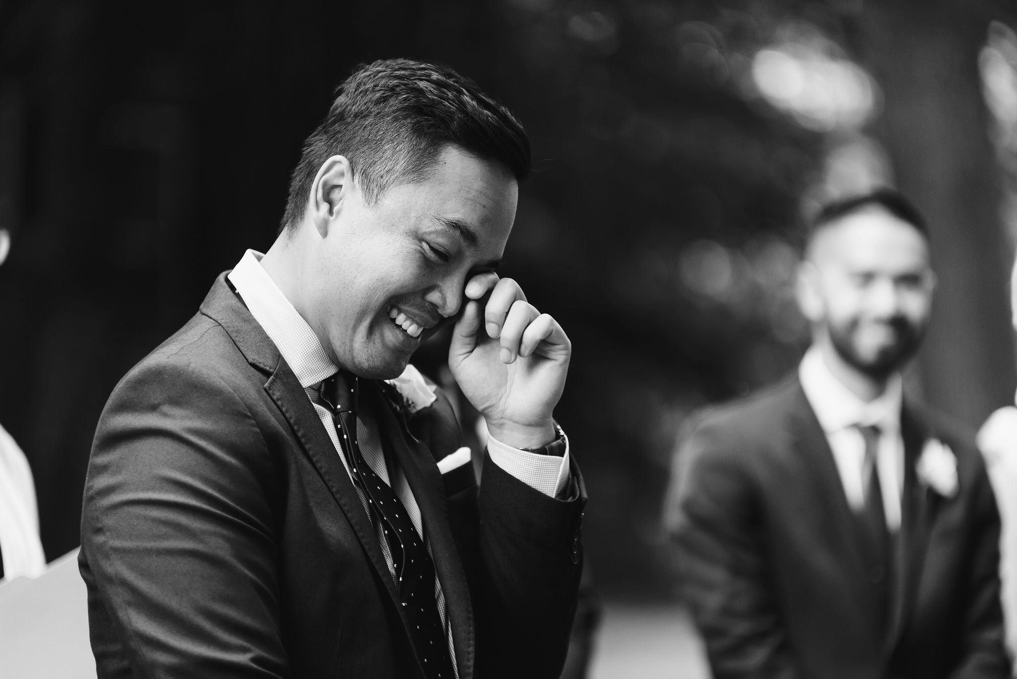 groom wiping a tear from his eye with his finger during wedding ceremony in Trinity Bellwoods Park Toronto