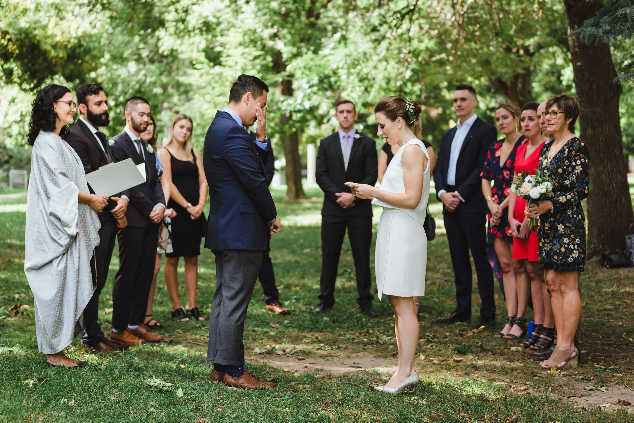 groom wiping a tear from his eye with his hand during wedding ceremony in Trinity Bellwoods Park Toronto