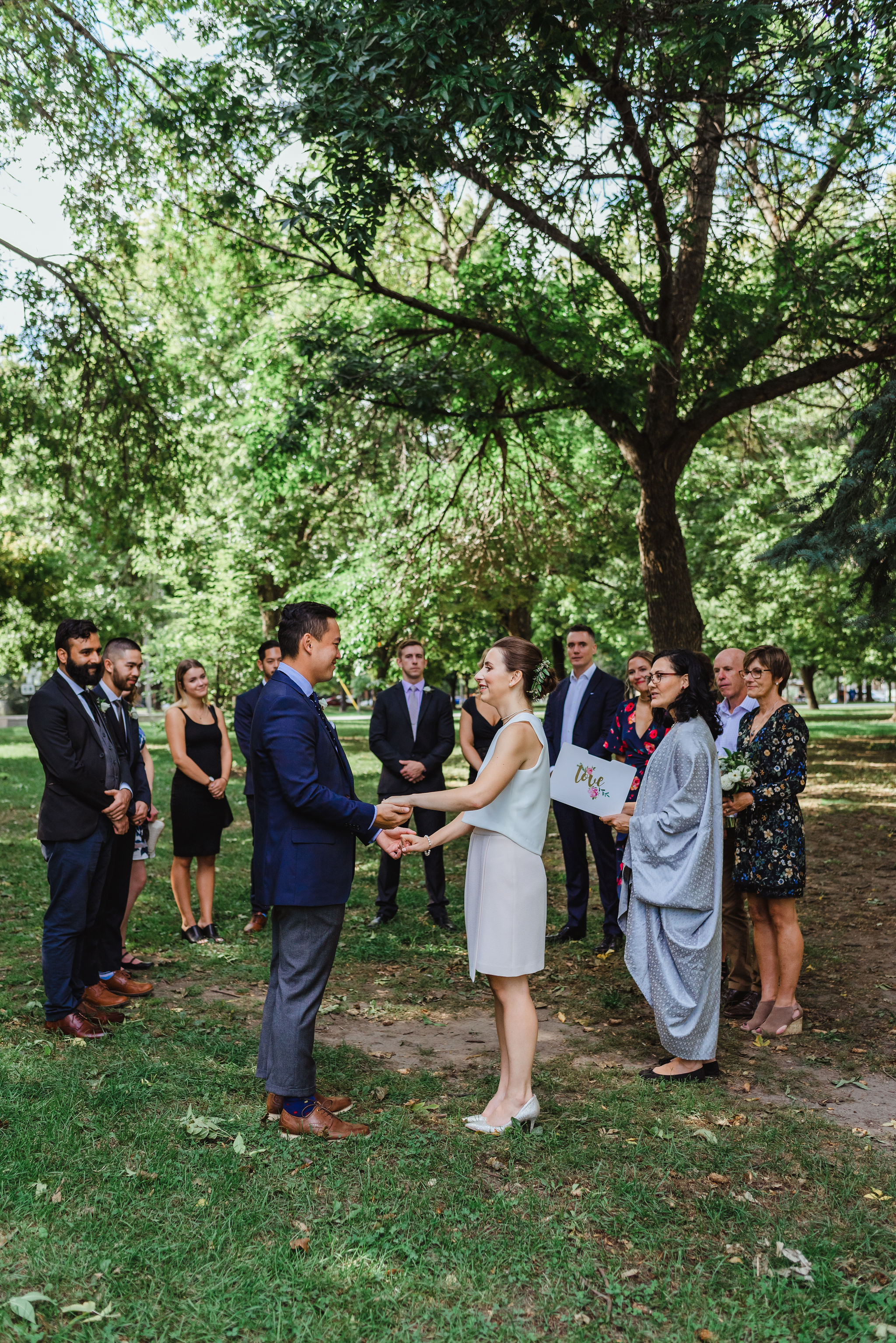 bride and groom holding hands during ceremony in Trinity Bellwoods Park Toronto