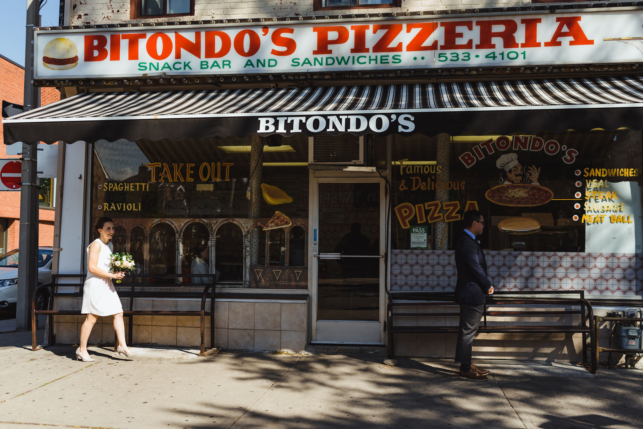 bride approaching groom for first look in front of Bitondo's Pizzeria Toronto Canada 