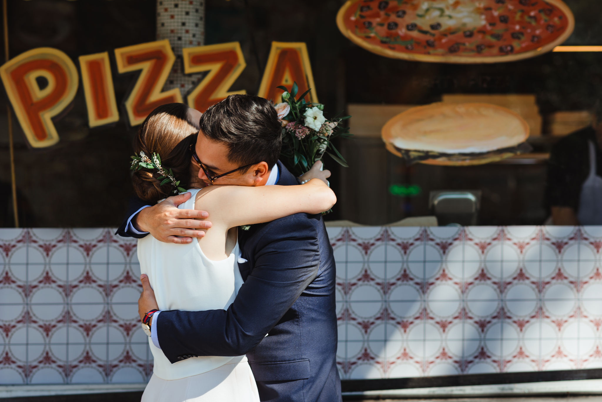 bride and groom hugging in front of Bitondo's Pizzeria Toronto Canada wedding photography