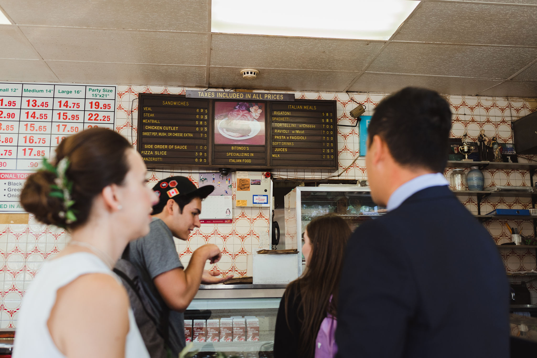 bride and groom ordering a pizza at Bitondo's Pizzeria Toronto Canada wedding photographer Gillian Foster