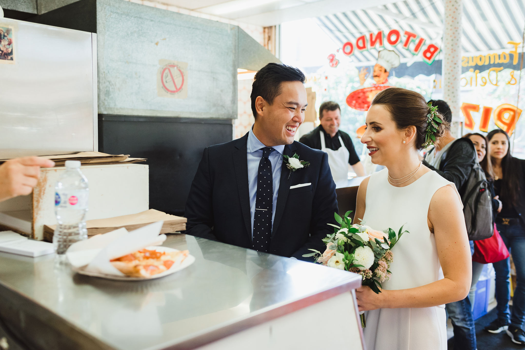 bride and groom smiling and ordering a pizza at Bitondo's Pizzeria Toronto Canada wedding 