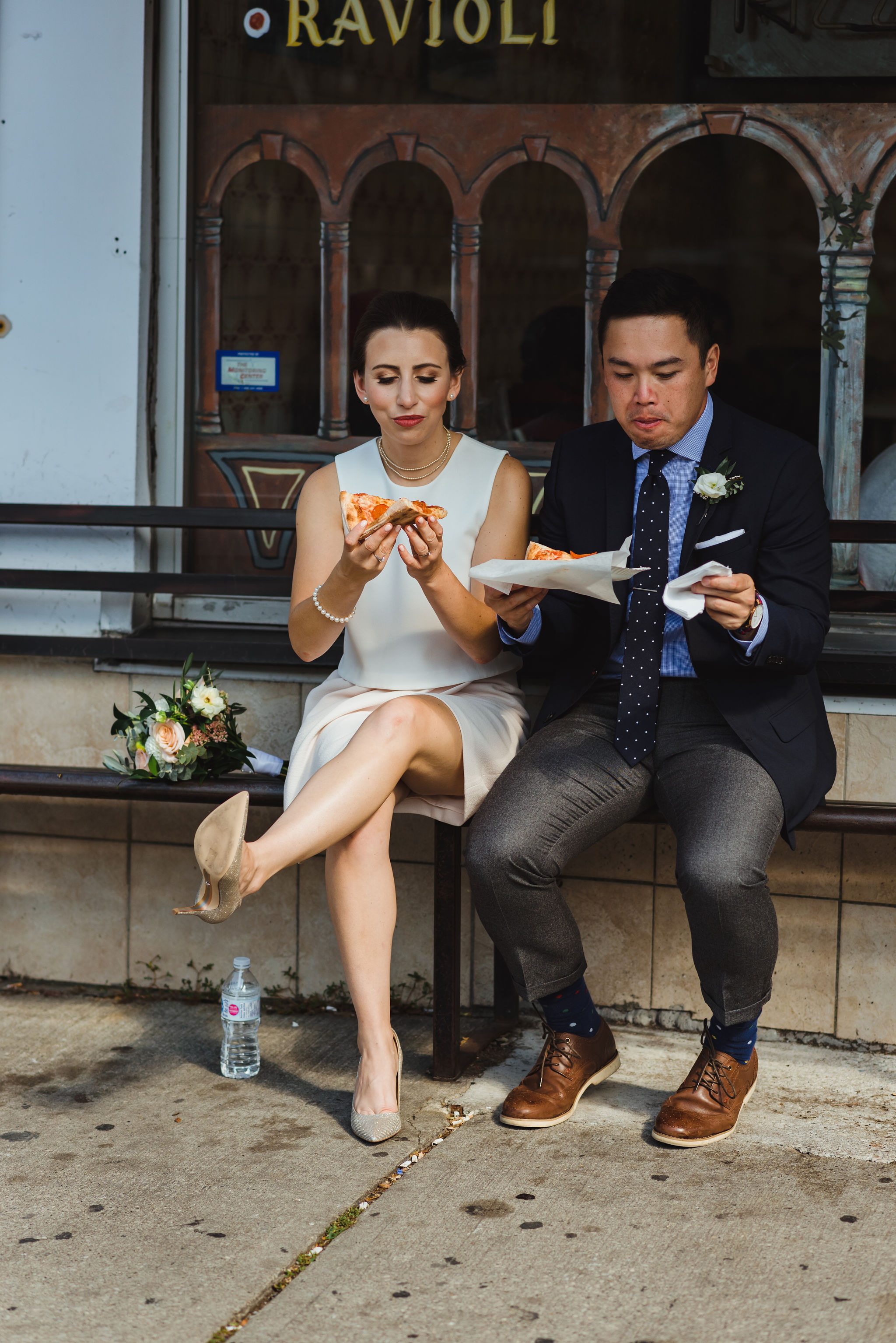 bride and groom outside of Bitondo's pizzeria eating slices of pizza Toronto Canada