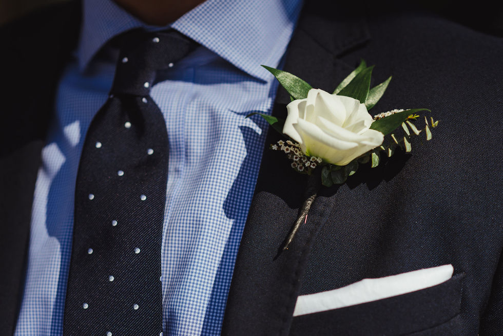 grooms blue suit and polkadot tie with white boutonniere 