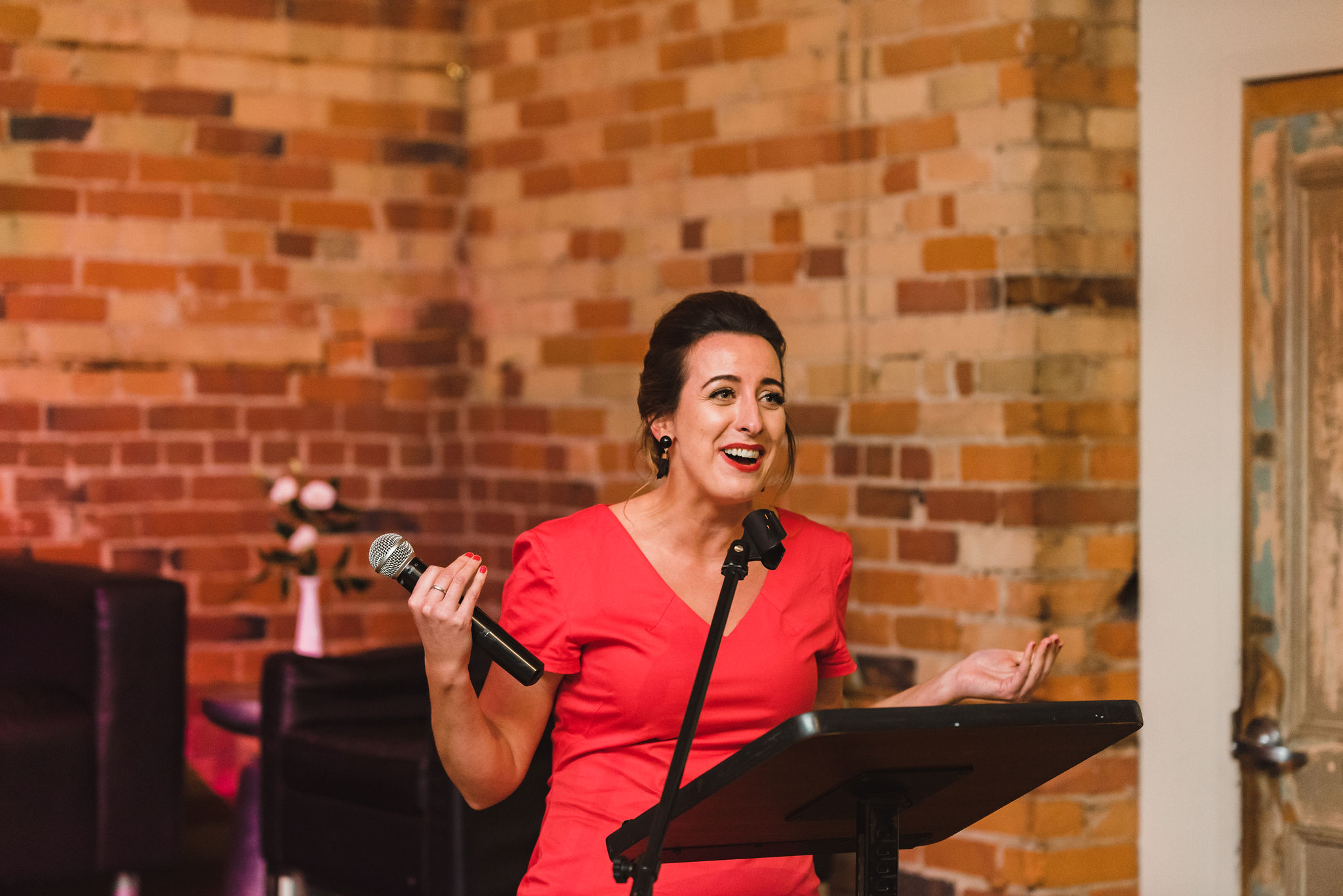 woman in a red dress giving a wedding speech at the Gladstone Hotel in Toronto how to best plan your wonderful wedding your way