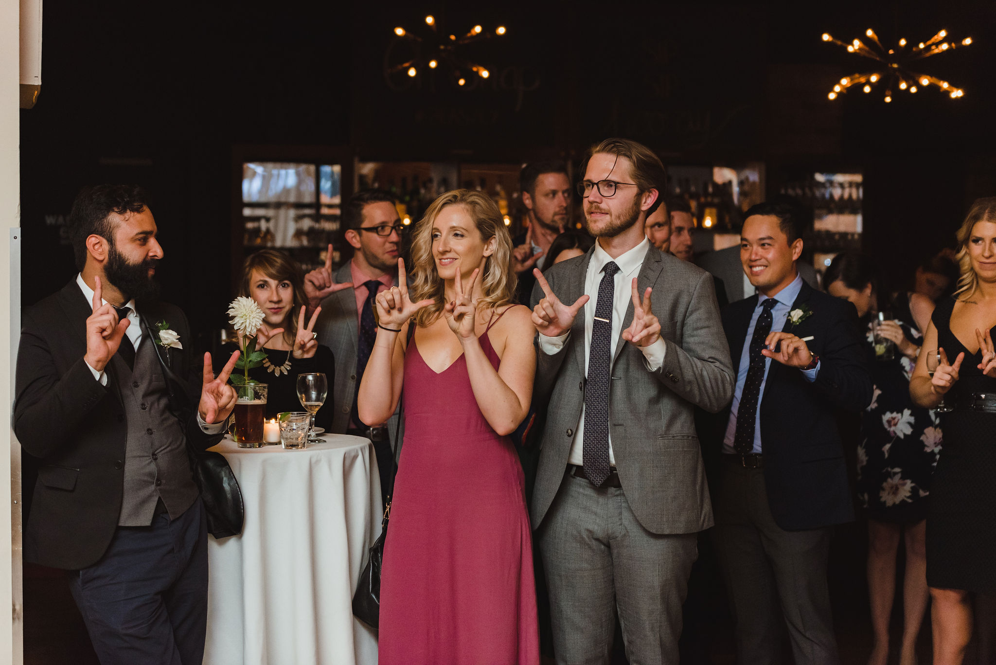 wedding guests all doing hand symbols during a wedding speech at the Gladstone Hotel in Toronto 