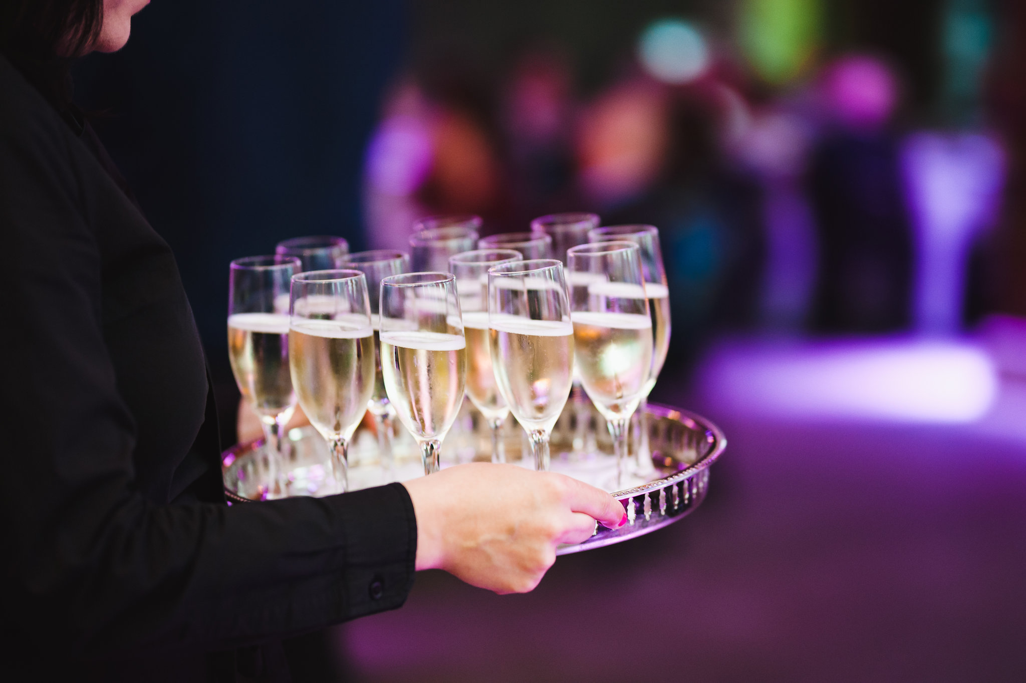 waiter carrying glasses of champagne through Steam Whistle's event space Toronto wedding photography