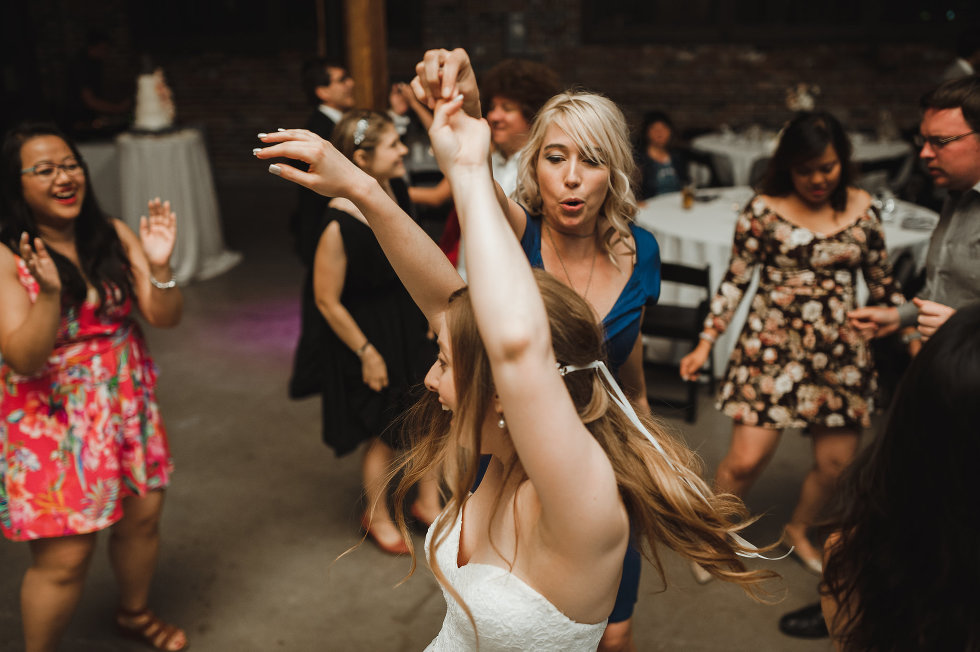 bride with her arms up and dancing during wedding reception at Steam Whistle Brewing