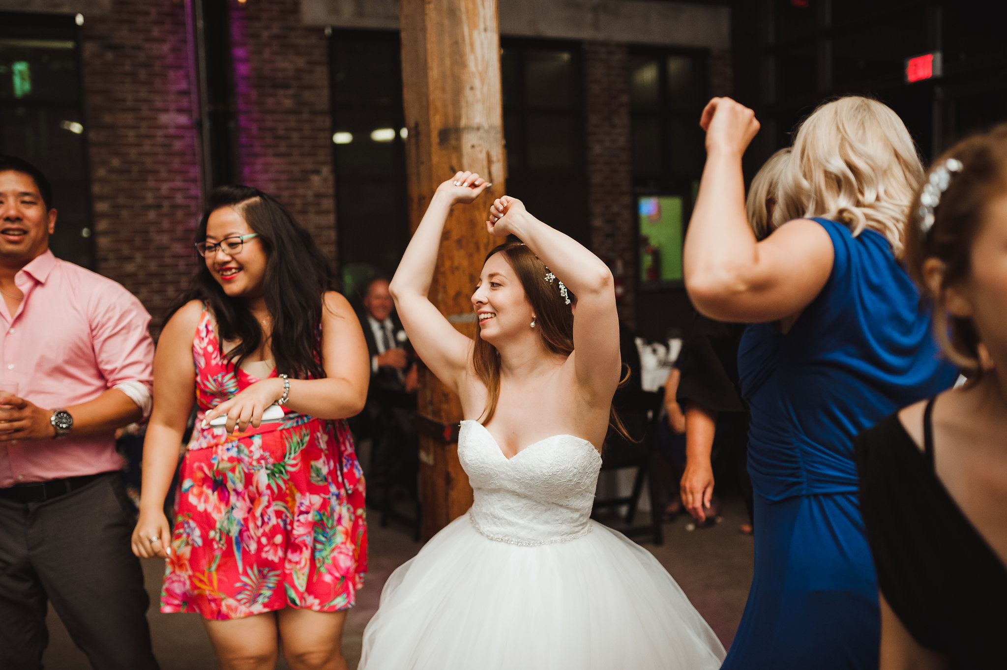 bride with her arms up and dancing during wedding reception at Steam Whistle Brewing Toronto wedding photographer Gillian Foster