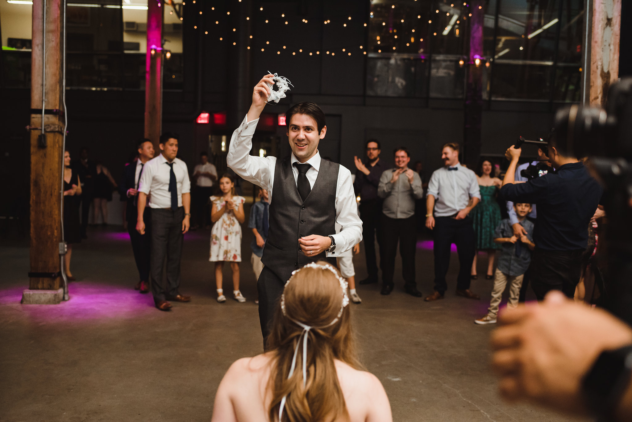 groom about to toss the garter to a group of wedding guests behind him Steam Whistle Brewing groom about to toss the garter to a group of wedding guests behind him Steam Whistle Brewing