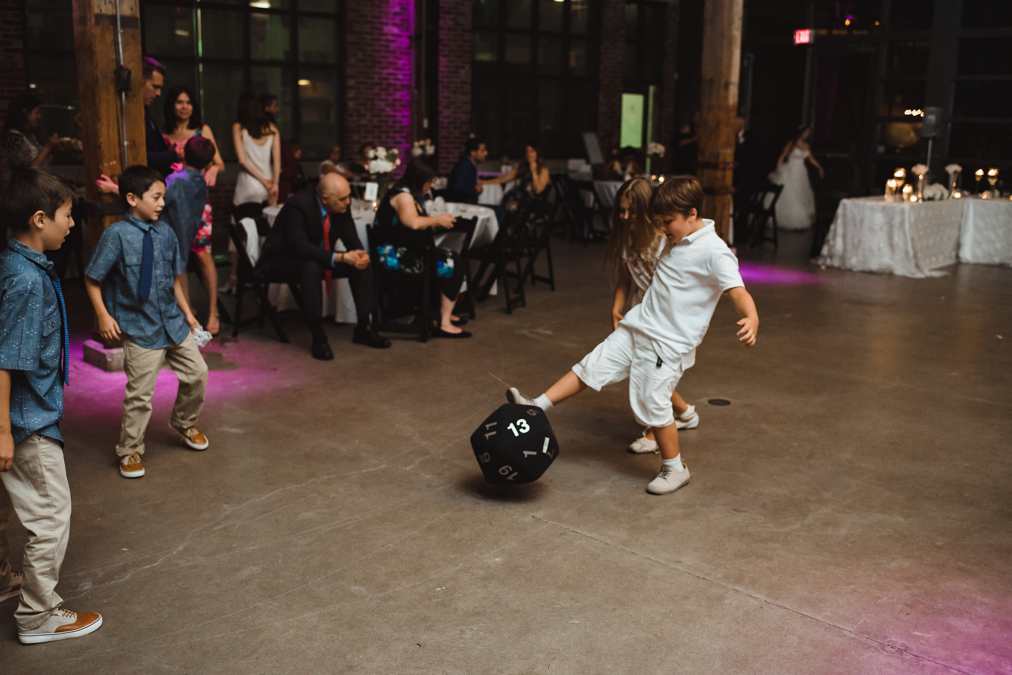 a group of children kicking around an oversized dice during a wedding at Steam Whistle Brewing a group of children kicking around an oversized dice during a wedding at Steam Whistle Brewing